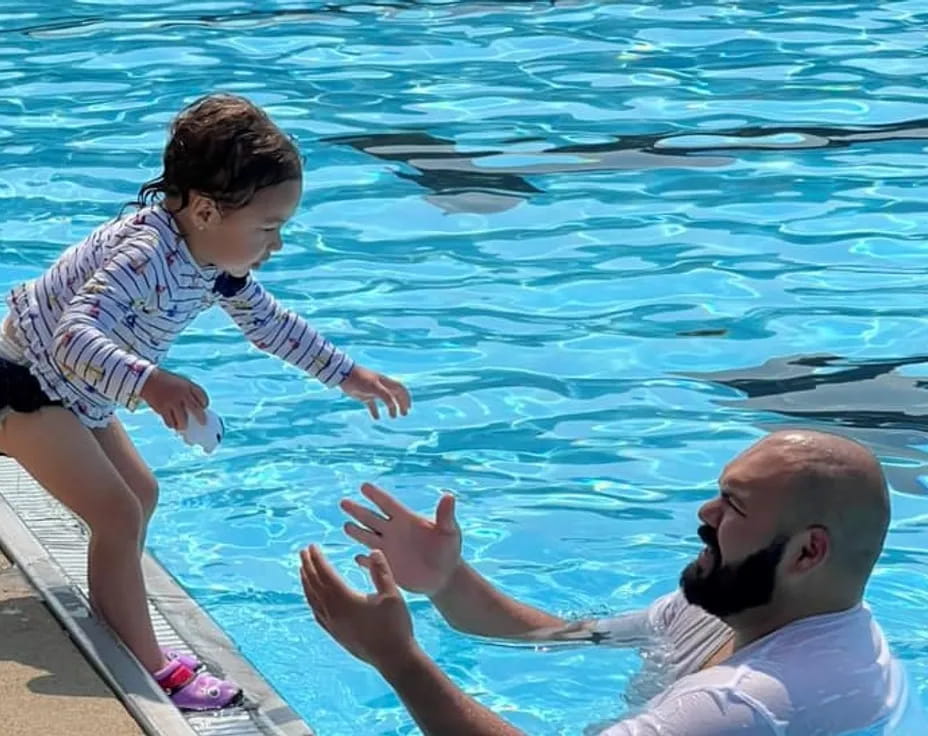 a person and a baby jumping into a pool