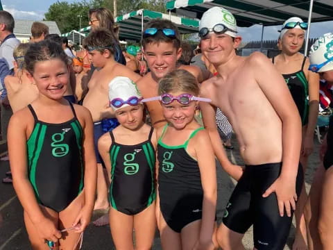 a group of people wearing swimsuits and standing in water