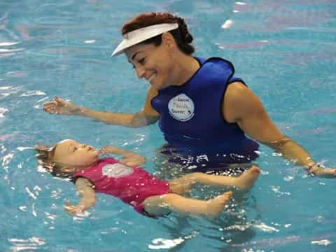 a person in a pool with a dolphin