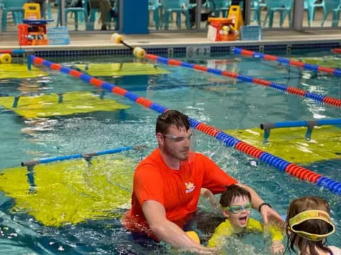 a man and two children in a pool