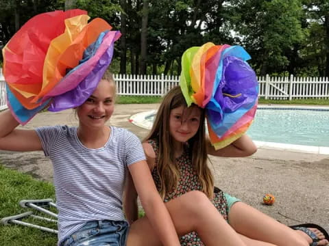 a couple of girls wearing colorful hats