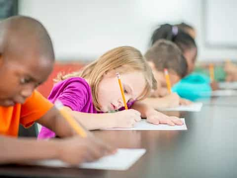 a few children writing on paper