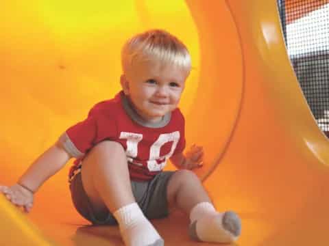 a boy sitting on a slide