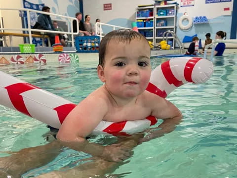 a boy in a pool with a toy in his hand