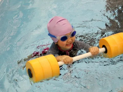 a child in a pool with a toy in it