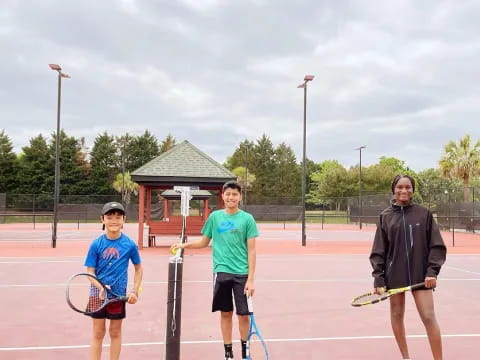 a group of men holding tennis rackets on a tennis court