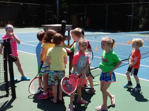a group of kids holding tennis rackets