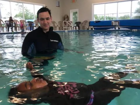 a man standing next to a dolphin in a pool