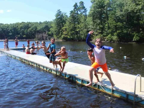 a group of people jumping into a pool of water