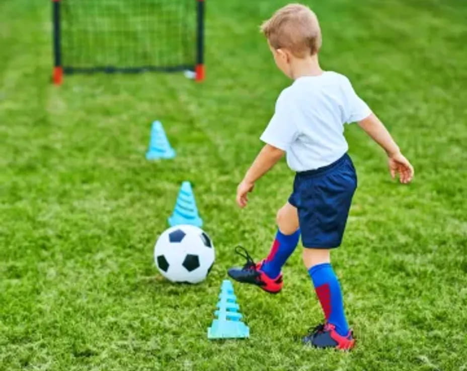 a boy playing with a football ball