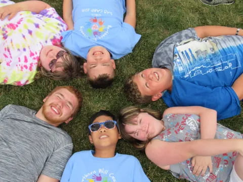 a group of people lying on the ground smiling for the camera