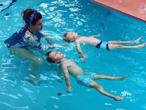 a woman and a man in a pool with a turtle