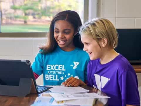 a few young girls looking at a laptop