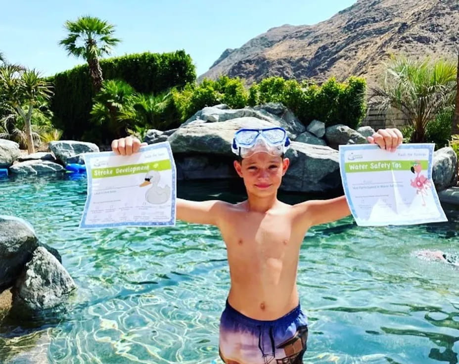 a boy holding a sign in a pool of water