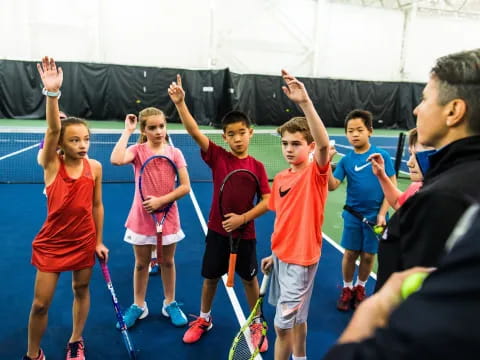 a group of kids holding tennis rackets