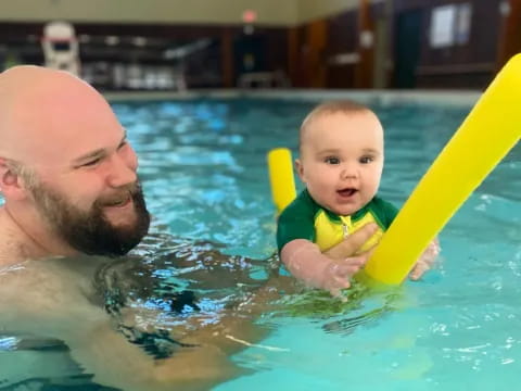 a man and a baby in a pool