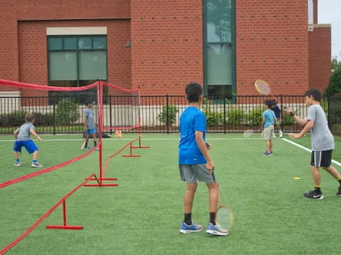 a group of kids playing tennis