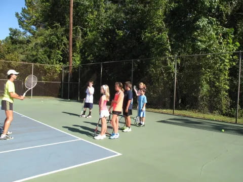 a group of kids playing tennis