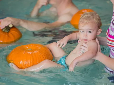 a baby in a pool with a toy in it