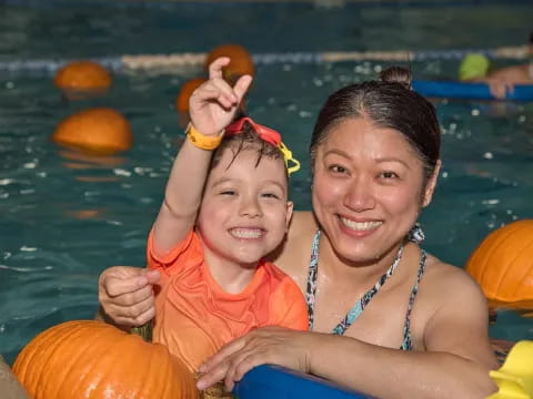 a person and a child in a pool with a floaty