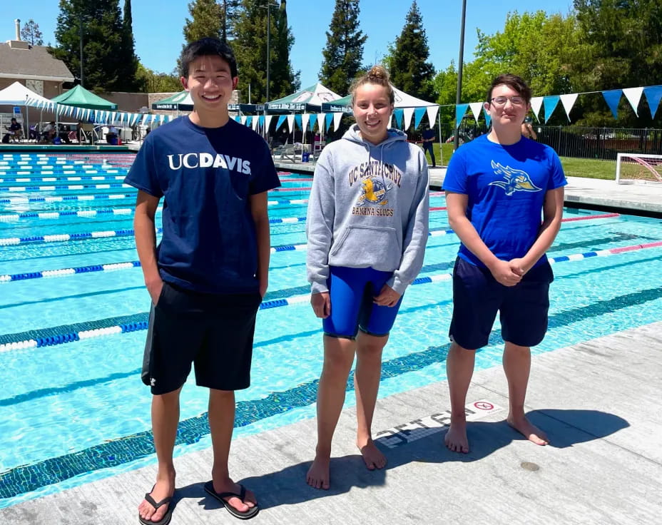 a group of people posing for a photo by a pool