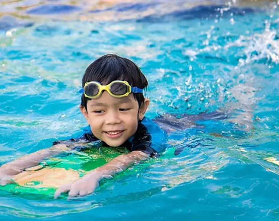 a boy wearing goggles in a pool