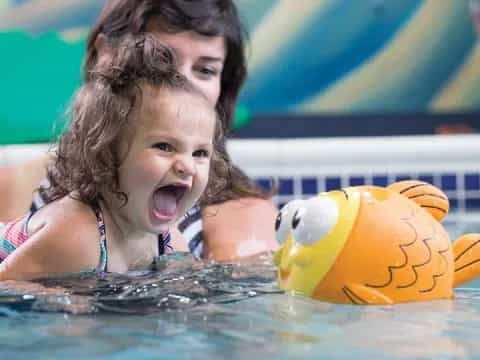 a girl in a pool with a ball