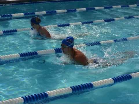 a couple of women swimming in a pool