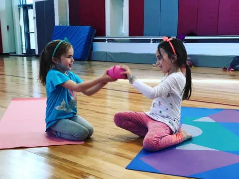 a couple of girls playing on mats