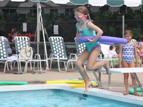 a person in a swimsuit jumping into a pool