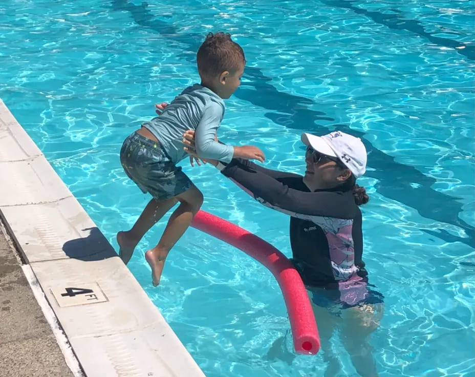 a couple of kids playing in a pool