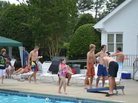 a group of people standing around a pool