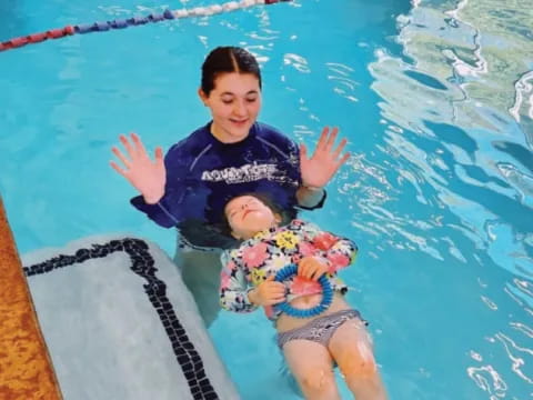 a person and a baby in a pool