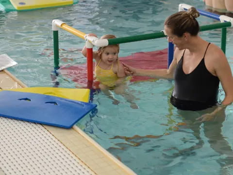 a person and a girl in a pool