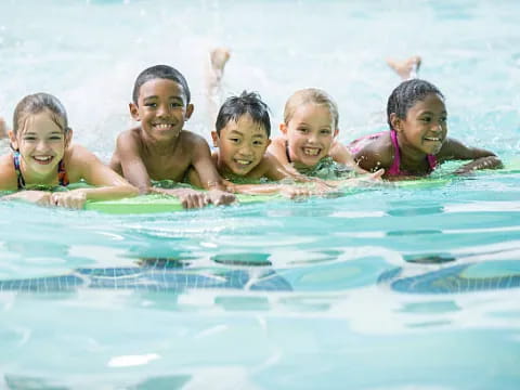 a group of children swimming in a pool
