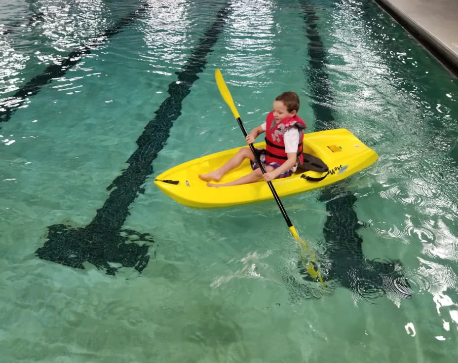 a boy in a yellow kayak