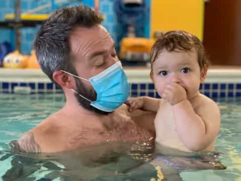 a man and a baby in a pool