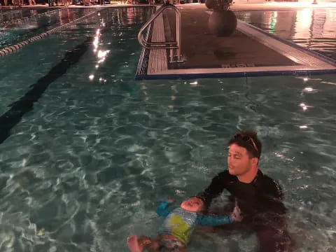 a man and a child in a pool at night