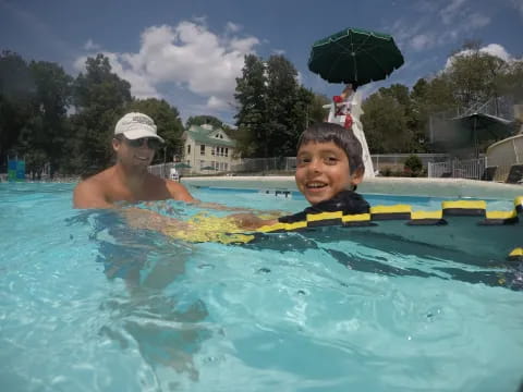 a person and a boy in a pool