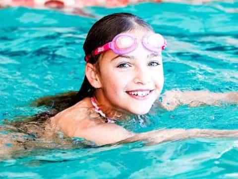 a girl wearing goggles in a pool