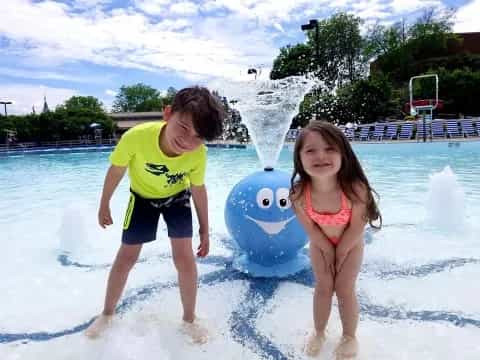 a boy and girl playing in a water park
