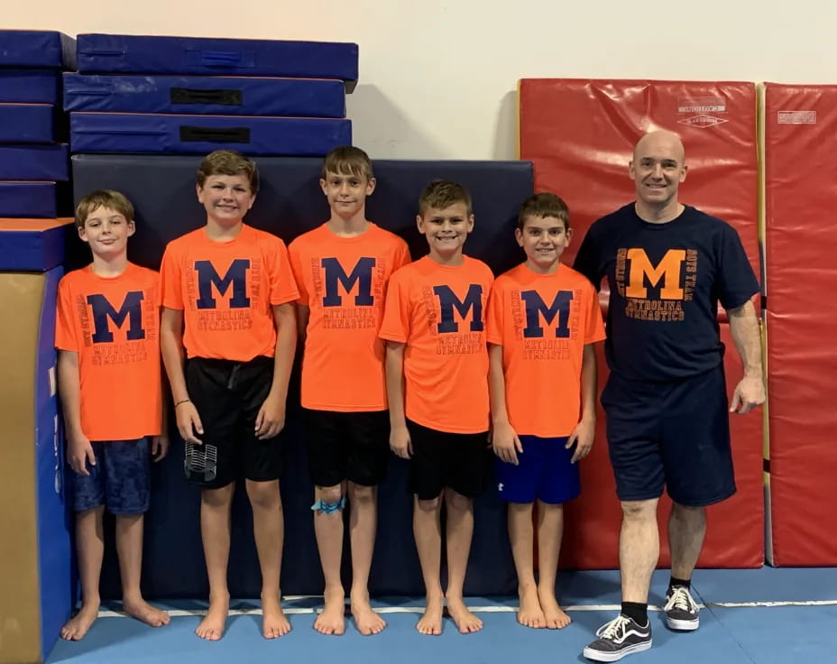 a group of boys in orange shirts