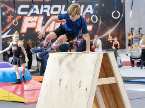 a boy jumping over a ramp