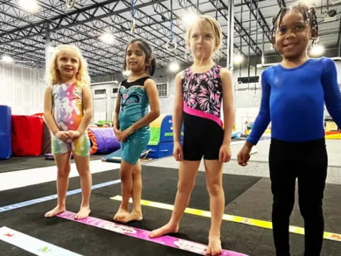 a group of girls standing on a mat