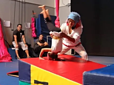 a person in a white robe doing a handstand on a red mat