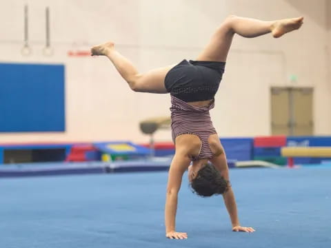 a woman doing a handstand on a mat