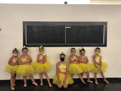 a group of girls in yellow dresses