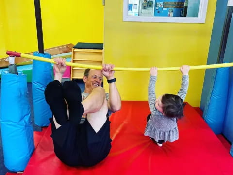 a couple of people on a red mat in a gym