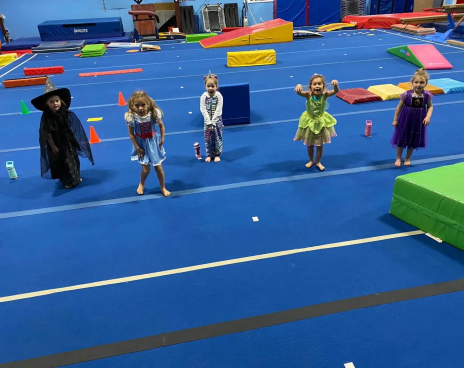 a group of children in clothing on a blue and yellow mat