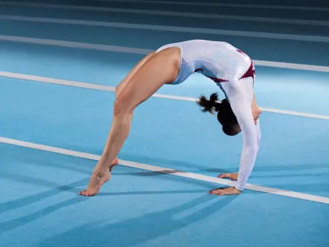 a person doing a handstand on a blue track